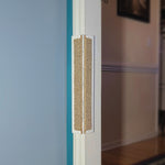 A door frame with a carpet Jack's Scratcher installed on it