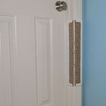 Carpet Jack's Scratcher installed on a white door frame with a white door and blue wall.
