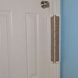 Carpet Jack's Scratcher installed on a white door frame with a white door and blue wall.
