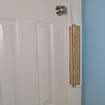 Sisal Jack's Scratcher installed on a white door frame with a white door and blue wall.
